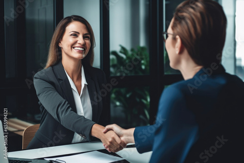 Smiling business woman shaking hands with partner