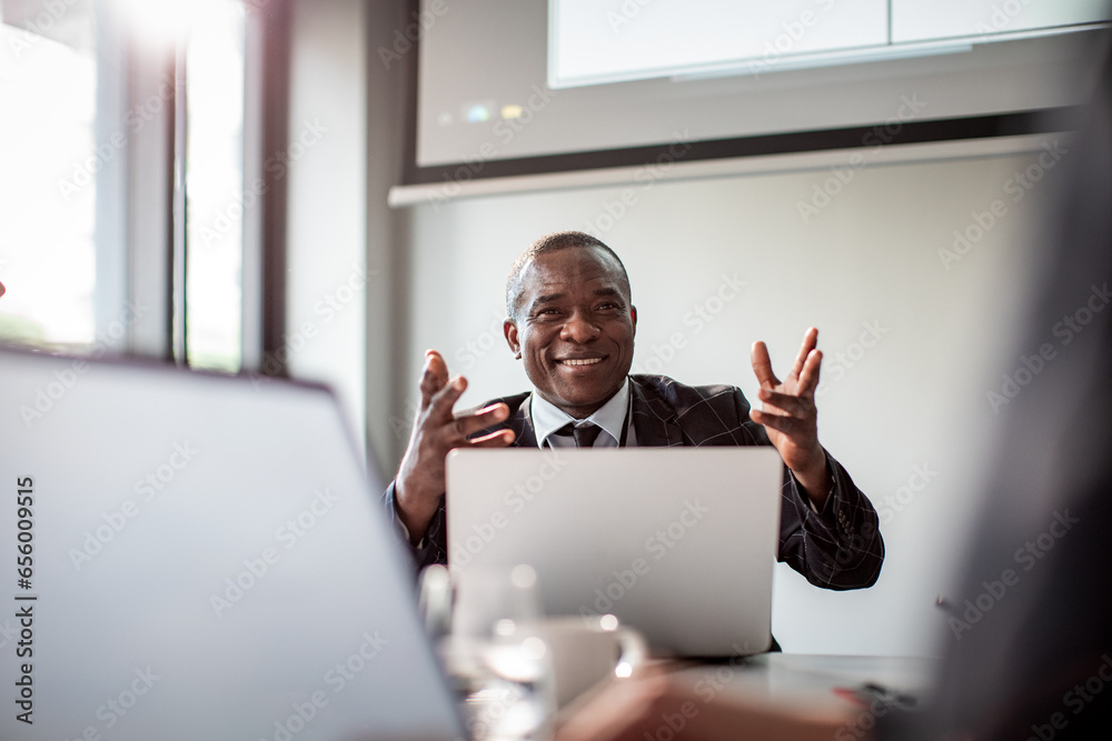 © Marko Geber - Young African American businessman presenting his project to his coworkers at the conference room © Marko Geber - Young African American businessman presenting his project to his coworkers at the conference room