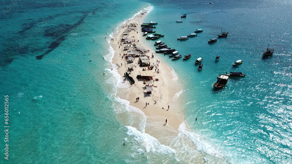 Aerial drone view of tiny and beautiful Nakupenda island on Zanzibar archipelago. Small sandy island is surrounded by many boats and incredible turquoise water of Indian ocean. Nakupenda, Zanzibar - obrazy, fototapety, plakaty 