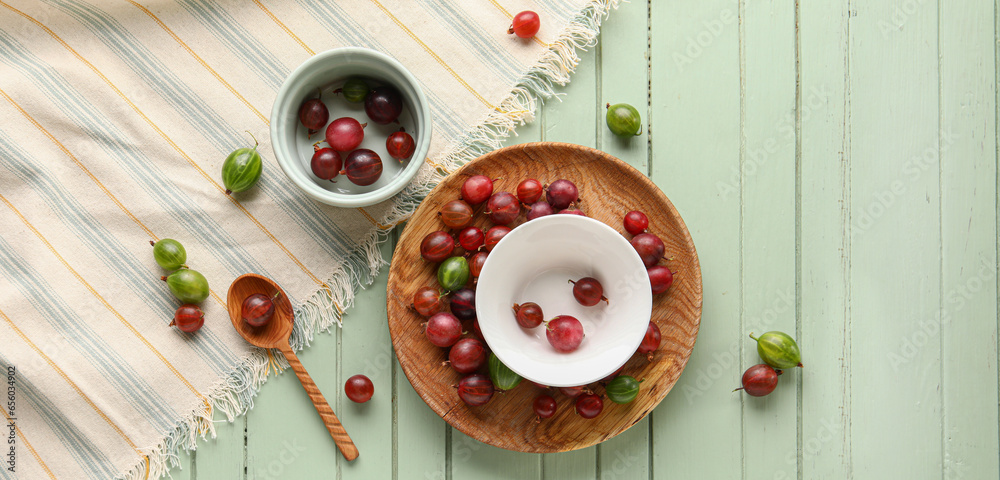 Composition with fresh gooseberries on green wooden background, top view