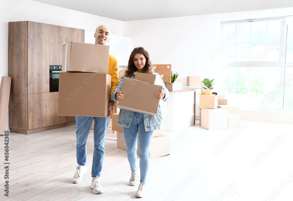 Young couple with cardboard boxes in kitchen on moving day Young couple with cardboard boxes in kitchen on moving day