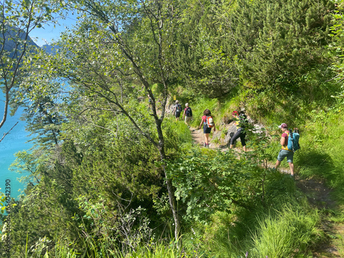 Eine Wandergruppe geht auf dem Geisalmsteig am Achensee während einer Alpenueberquerung