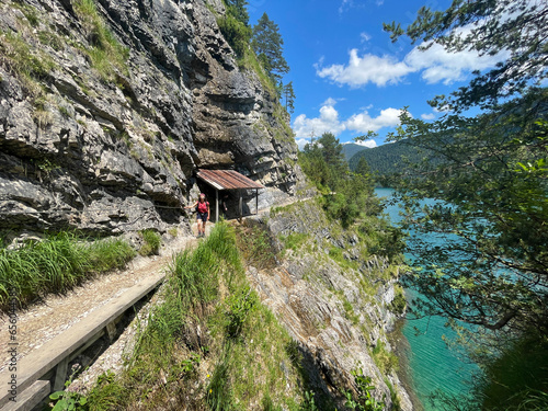 Eine Wanderin steht auf dem Geisalmsteig am Achensee während einer Alpenueberquerung in Tirol in Österreich
