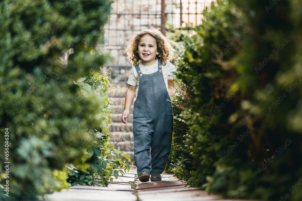 portrait of happy little boy and model, walking through medieval city garden, sightseeing portrait of happy little boy and model, walking through medieval city garden, sightseeing