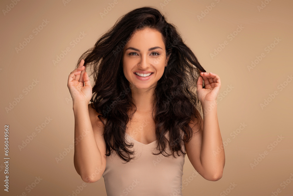 Portrait of smiling indian woman touching beautiful dark long hair Portrait of smiling indian woman touching beautiful dark long hair
