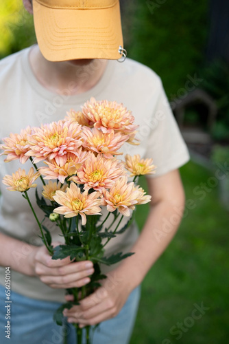 a girl in a cap with a chrysanthemum