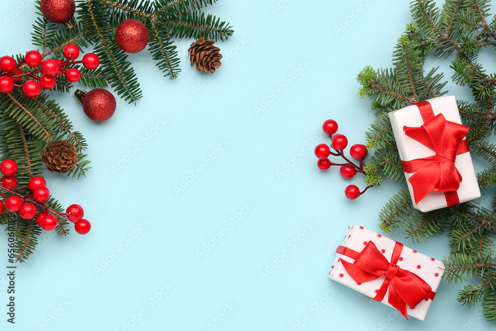 Christmas tree branches with gift boxes, balls and rowan on blue background Christmas tree branches with gift boxes, balls and rowan on blue background