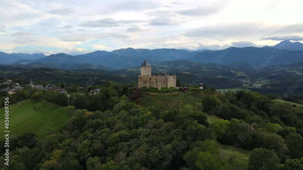 Majestic Castle of Mauvezin dominates a scenic European countryside, surrounded by quaint homes and serene mountain ranges in the distance. Majestic Castle of Mauvezin dominates a scenic European countryside, surrounded by quaint homes and serene mountain ranges in the distance.