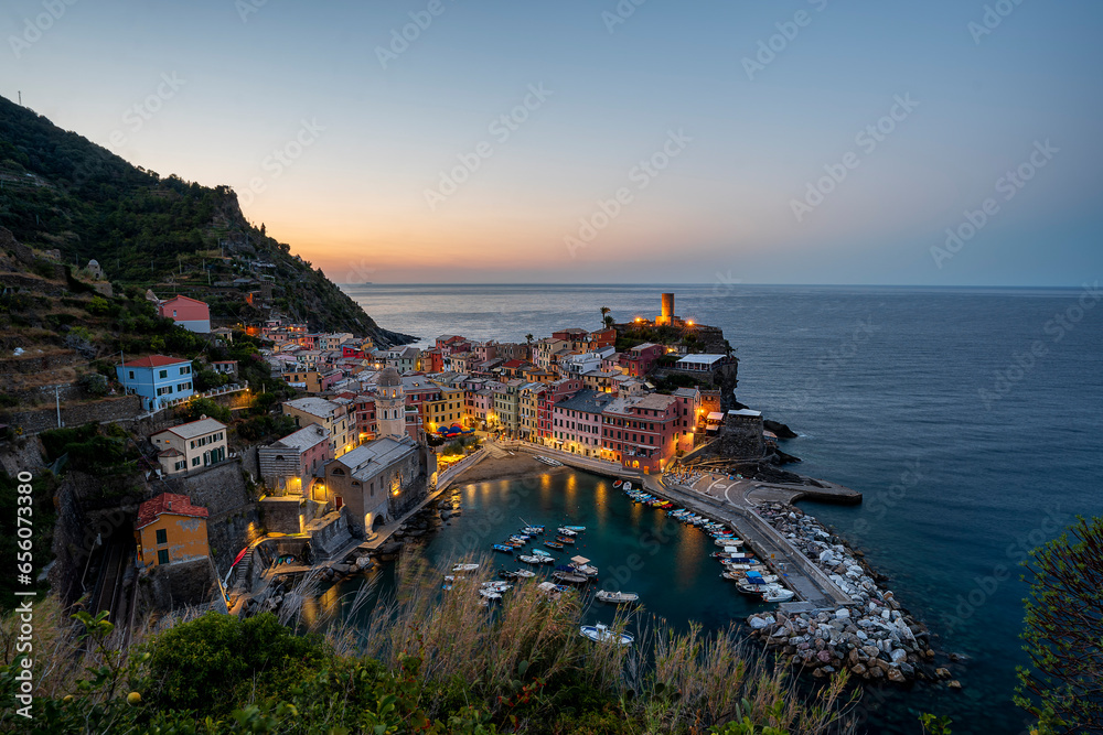 Incredible view during morning blue hour on the illuminated village of Vernazza, Cinque Terre, Italy