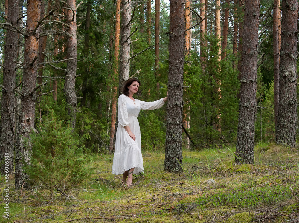 Beautiful woman in a white dress in the forest Beautiful woman in a white dress in the forest