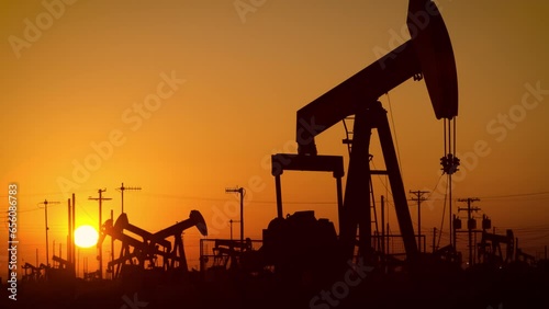 The sun rises behind oil pumps in California