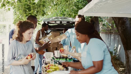 Hunger relief team, comprising of African Americans and Caucasians, distribute donated food to the homeless and others in need. Charity workers providing humanitarian aid to the less privileged.