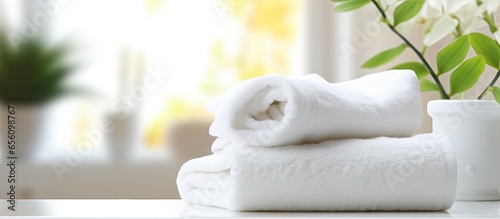 White towels arranged on white table ideal for showcasing products in a blurred living room background