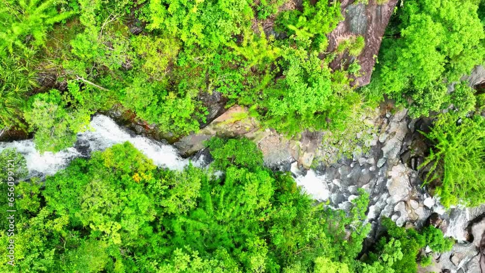 Aerial view of lush tropical forest with cascading waterfall from towering cliff. Nature's beauty in full display. Soi Sawan Waterfall, Pha Taem National Park, Ubon Ratchathani Province, Thailand.
Aerial view of lush tropical forest with cascading waterfall from towering cliff. Nature's beauty in full display. Soi Sawan Waterfall, Pha Taem National Park, Ubon Ratchathani Province, Thailand.