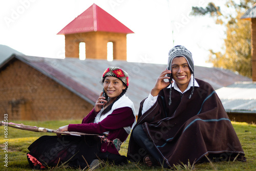 Un par de campesinos sentados muy alegres hablando por teléfono celular al aire libre, mujer y hombre campesino agricultor inteligente se comunica con entusiasmo en conferencia en línea al aire libre,