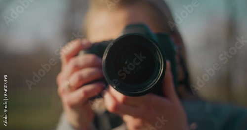 Female explorer photographing through camera in park