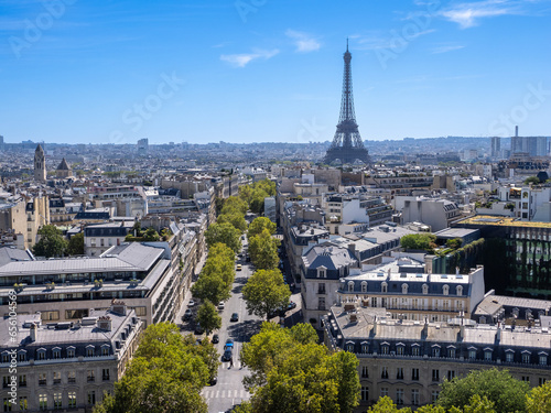 On a clear sky, summer day, the landmark Eiffel Tower stands proudly oave the currounding streets and apartments in Paris, France.,  © luxborealis