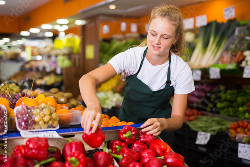 Obraz na plátně Fifteen-year-old girl who works part-time in a store as a trainee saleswoman put
