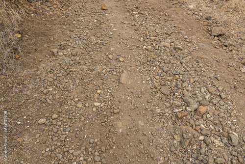 Santa Cruz Island, CA, USA - September 14, 2023: unstable surface of smugglers trail closeup, brown pebbles of all sizes and dirt