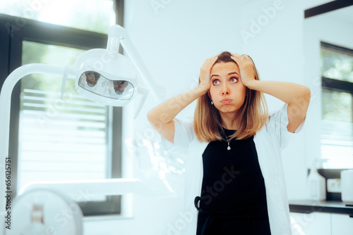 Exasperated Stressed Dentist Feeling Concerned Standing in her Cabinet. Dental care worker being frustrated with overtime schedule  
