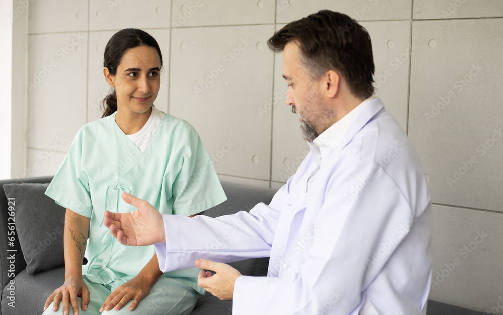 Caucasian doctor working as physiotherapist for stretching and rehabilitation Hispanic patient's injury and painful body. Medical and healthcare recovery at hospital concept. Caucasian doctor working as physiotherapist for stretching and rehabilitation Hispanic patient's injury and painful body. Medical and healthcare recovery at hospital concept.