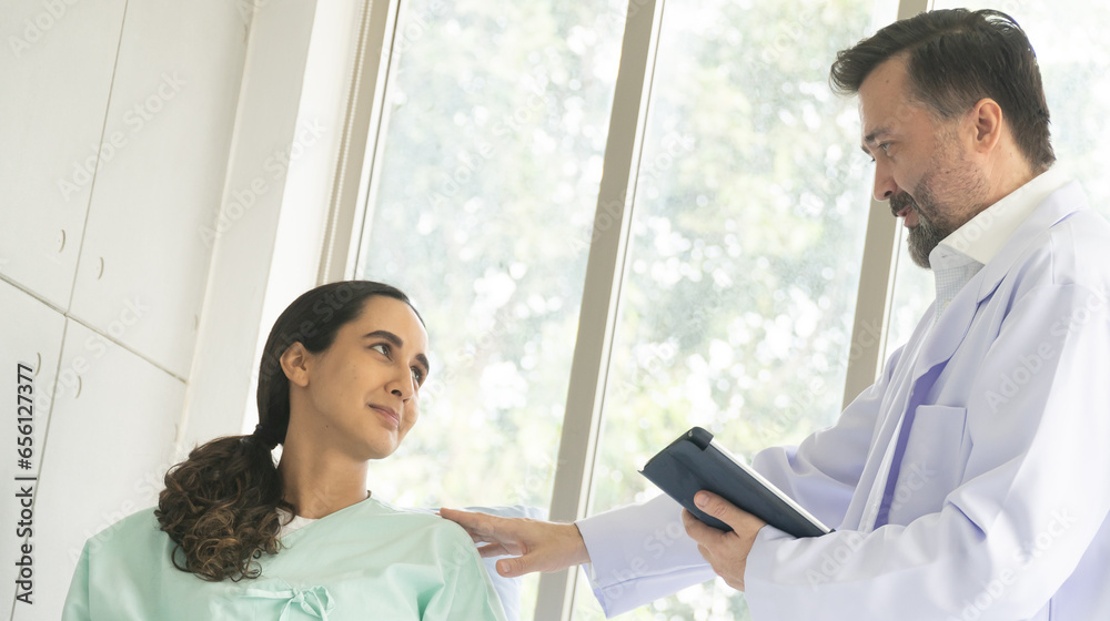 Obraz premium Caucasian male physician diagnosis for root cause finding working on tablet with Hispanic female patient. The medical healthcare exam and check-up with the doctor concept.