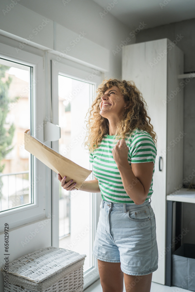 caucasian woman open mail letter or document envelope at home