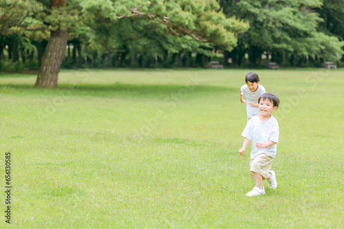 公園で追いかけっこする活発な子供達・兄弟・走る・短距離走 