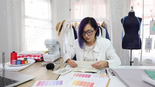 Fashionable freelance dressmaker is designing on new dress by drawing illustrator while working in artistic workshop studio for fashion design and clothing business industry