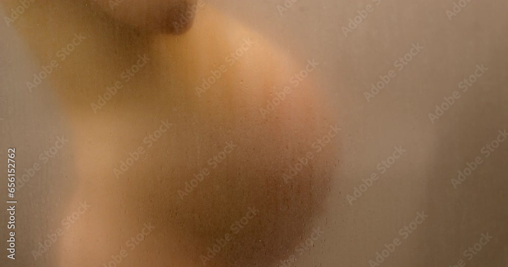 Pregnancy concept video. Pregnant woman belly closeup in shower. Tastefully beautiful naked foggy out of focus blurred pregnancy body during 3rd trimester. Maternity photo steam bath. Expectant woman. Pregnancy concept video. Pregnant woman belly closeup in shower. Tastefully beautiful naked foggy out of focus blurred pregnancy body during 3rd trimester. Maternity photo steam bath. Expectant woman.