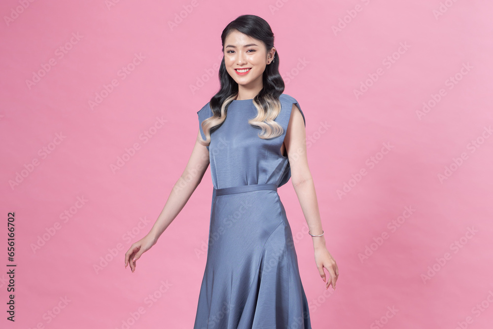 Full length image of young Asian woman wearing blue dress on pink background Full length image of young Asian woman wearing blue dress on pink background