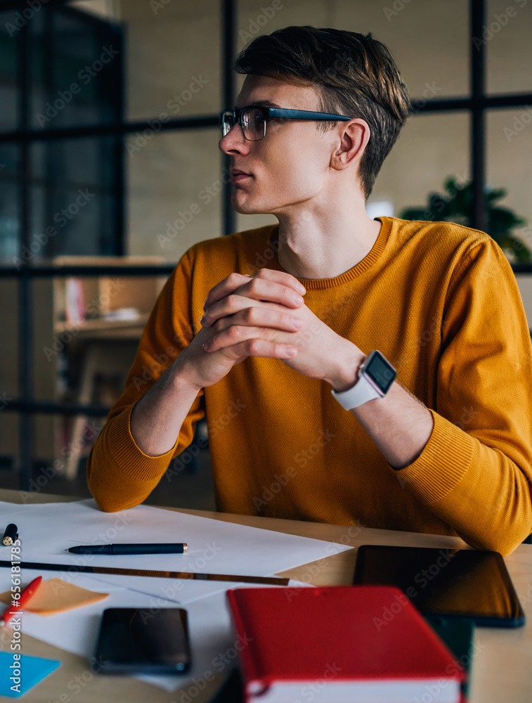 Naklejka premium Thoughtful young man thinking on ideas for design project working in studio