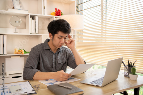Stressed Young Businessman Facing Financial Loss in Corporate Office, Depressed man Dealing with Financial Setback, Stress and Money Problems, Anxiety and Worry Concept.