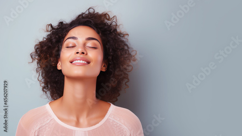A woman closed eyes breathes relaxedly isolated on pastel background photo