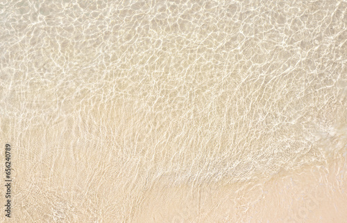 Summer sea natural background Beige surface  clear water with ripples and splashes. water waves in sunlight The water surface has waves.