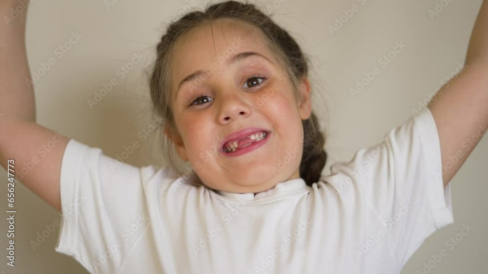 Happy child smiles with his teeth at camera. Cute little girl in bright ...