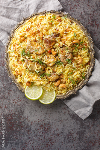 Kacchi Mutton Biryani is a delicious rice dish where tender lamb meat pieces are marinated with lots of spicy closeup on the plate on the table. Vertical top view from above photo