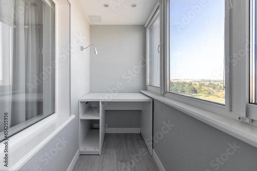 Modern interior of the loggia of white color with lighting, table and window photo