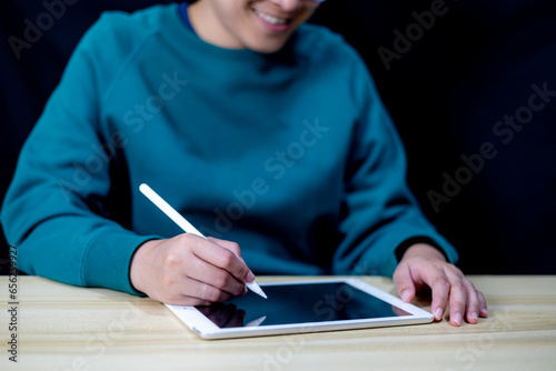 Young woman used her tablet for data analysis and information recording. using tablet for shopping online. blank screen of smart-tablet for advertisement, business information searching. communication