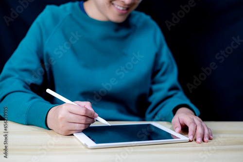 Young woman used her tablet for data analysis and information recording. using tablet for shopping online. blank screen of smart-tablet for advertisement, business information searching. communication
