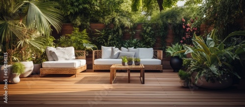 A stylish wooden terrace with wicker garden furniture plants and flowers a soothing place for a sunny summer day