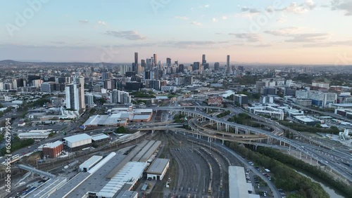 Establishing pull away drone shot of Brisbane City, with Mayne Railway Yard and the ICB inner city bypass. Shot during sunset, city Skyline standing tall against lovely sunset sky. photo