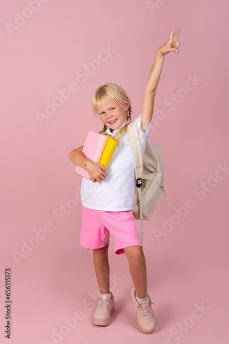 Girl with books in her hands and a backpack.