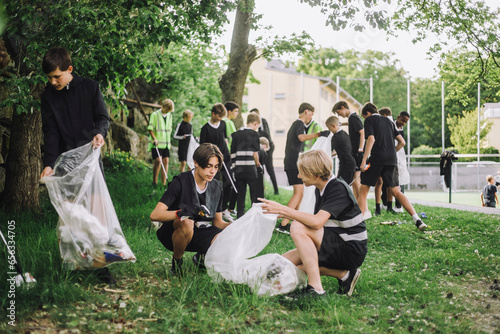 Boys collecting garbage in plastic bags