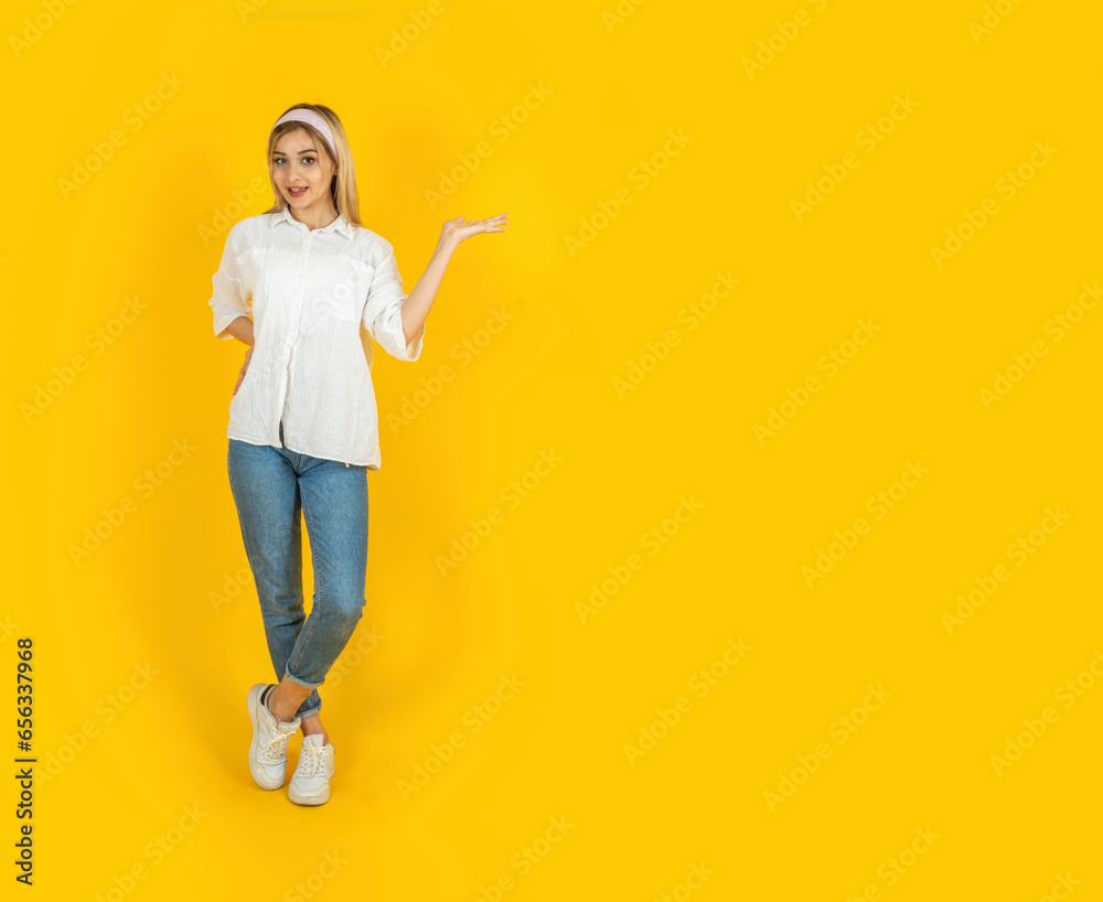 Woman offering new product, full body view young caucasian blonde woman offering new product. Happy smiling girl holding copy space on her open palm. Product display advertising concept idea image. Woman offering new product, full body view young caucasian blonde woman offering new product. Happy smiling girl holding copy space on her open palm. Product display advertising concept idea image.