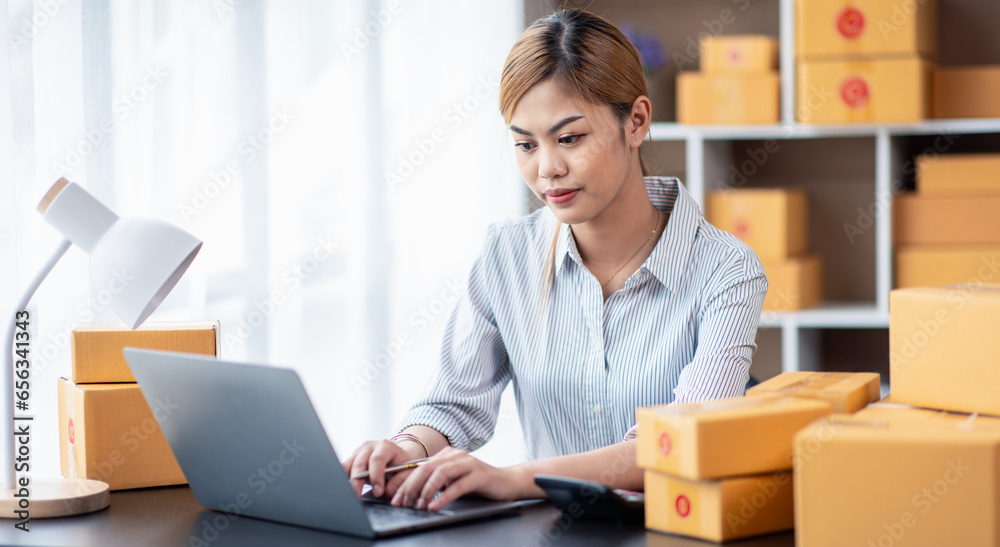 Young Asian girl Entrepreneurs, SME businesses check orders and check the purchase order Prepare parcels for asian businesswoman running an e-commerce Sme small delivery. Young Asian girl Entrepreneurs, SME businesses check orders and check the purchase order Prepare parcels for asian businesswoman running an e-commerce Sme small delivery.