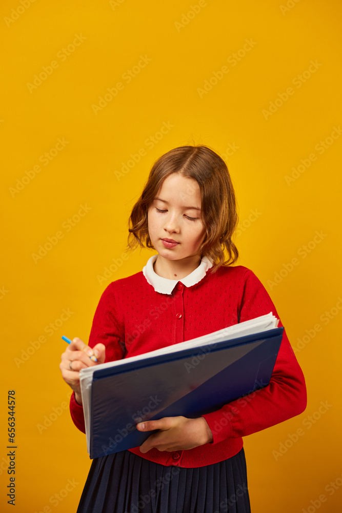 Thoughtful School teenage girl holding pen and write on notebook Thoughtful School teenage girl holding pen and write on notebook