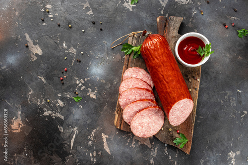 Smoked sausage salami with slices on a dark background. banner, menu, recipe place for text, top view