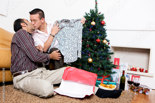 Gay Christmas: A single sex male couple sharing gifts and enjoying each others company on Christmas Day. photo