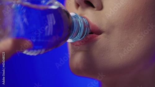 Dziewczyna pije wode z butelki plastikowej photo